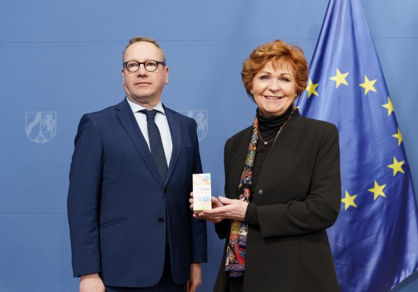Justizminister Limbach und die Opferbeauftragte Havliza halten eine Packung K.O.-Tropfen-Schutz-Armband in die Kamera