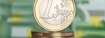 Ein Stapel Euro-Münzen vor einem Euroschein